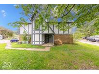 Charming townhome featuring a well-maintained lawn and classic Tudor-style architecture at 9855 Haven Ct, Indianapolis, IN 46235