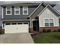 Charming two-story home with a well-manicured lawn, a two-car garage, and a welcoming front entrance at 1303 Eton Way, Avon, IN 46123