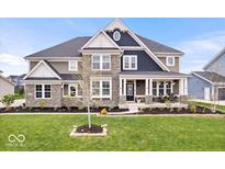 Beautiful two-story home featuring stone accents, a welcoming front porch, and professionally landscaped front yard at 1352 Trifecta Way, Westfield, IN 46074