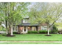 Charming two-story home boasts a manicured lawn and mature trees at 13948 Silver Stream Dr, Carmel, IN 46032