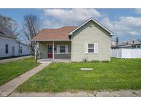 Charming home featuring a quaint covered porch, a red front door and a well-maintained front yard at 218 E Mechanic St, Shelbyville, IN 46176