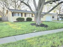 Charming single-story home with a well-maintained lawn and large tree in the front yard at 2465 N Eaton Ave, Indianapolis, IN 46219