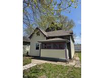 Charming home with siding and porch needing some TLC, surrounded by a lush green yard at 325 Harlan St, Indianapolis, IN 46201