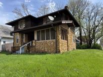 Charming two-story home featuring a stone exterior and a cozy screened-in front porch at 3601 N Kenwood Ave, Indianapolis, IN 46208