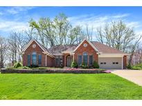 Beautiful red brick home with well-manicured lawn and blooming flower beds in a suburban setting at 424 Orchard Blvd, Danville, IN 46122