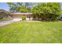 Charming single-story home with a well-maintained lawn, mature tree, and attached two-car garage at 4710 E 56Th St, Indianapolis, IN 46220