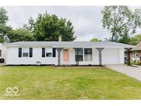 Charming single-story home featuring a white exterior, black shutters, a pink door, and a well-maintained front lawn at 4916 N Richardt Ave, Indianapolis, IN 46226