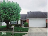 Charming single-story home featuring a brick facade, well-manicured lawn, and attached two-car garage at 5341 Spring Creek Ct, Indianapolis, IN 46254