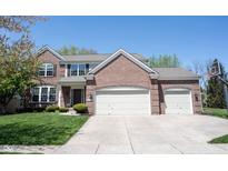Traditional brick home featuring a three-car garage and well-maintained landscaping at 5624 Ottawa Pass, Carmel, IN 46033