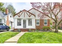 Charming home with a well-manicured lawn, brick accents, and beautiful blossoming tree at 5933 Guilford Ave, Indianapolis, IN 46220