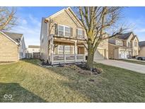 Well-maintained home with a lush lawn, a charming front porch, and a two-car garage at 8327 Andrusia Ln, Indianapolis, IN 46237