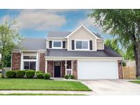 Inviting two-story home with brick and vinyl siding, attached garage, and well-manicured lawn at 10982 Gate Cir, Fishers, IN 46038