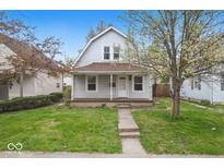 Charming home with a well-maintained lawn, a pathway and mature tree in front yard at 122 S 3Rd Ave, Beech Grove, IN 46107