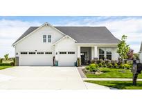 Charming two-story home featuring a three-car garage, complemented by a well-manicured lawn and lush landscaping at 1242 Petit Verdot Dr, Westfield, IN 46074