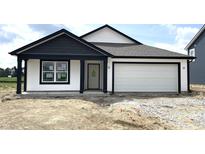 Charming single-story home featuring white siding, a two-car garage and contrasting black trim at 1319 Fleming Dr, Greenfield, IN 46140
