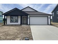Charming single-story home with a two-car garage, dark trim, and a concrete driveway at 1319 Fleming Dr, Greenfield, IN 46140