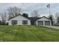 Charming home with lush green lawn, brick accents, and attached two-car garage at 1873 W 950 S, Pendleton, IN 46064