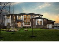 Stunning two-story home at twilight with a meticulously maintained lawn, modern windows, and inviting exterior lighting at 4292 Alderborough Way, Zionsville, IN 46077