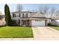 Charming two-story home with brick accents, a manicured lawn, and a two car garage on a sunny day at 6075 Bristlecone Dr, Fishers, IN 46038
