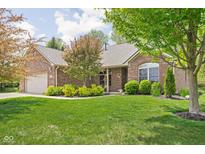 Charming brick home with a well-manicured lawn and mature trees in a desirable neighborhood at 7340 Stones River Dr, Indianapolis, IN 46259