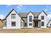 New construction home boasts painted brick, black trim windows and gabled roof against a cloudy blue sky at 8082 Abington Way, Zionsville, IN 46077