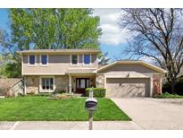 Charming two-story home with a manicured lawn, stone accents, and an attached two-car garage at 8332 Tanager Ln, Indianapolis, IN 46256