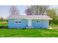 Charming single-story home featuring blue siding, a well-kept lawn, and mature trees at 1004 Shepherd Rd, Anderson, IN 46012