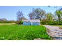 Charming single-story home featuring a well-manicured lawn and a classic white front door at 1004 Shepherd Rd, Anderson, IN 46012
