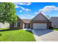 Charming brick ranch with a well-manicured lawn and attached two-car garage at 1649 Woodfield Dr, Greenwood, IN 46143