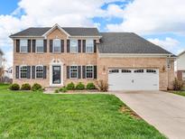 Inviting two-story brick home with manicured lawn and a two-car garage on a sunny day at 1968 Saratoga Dr, Greenwood, IN 46143
