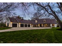 An impressive home featuring stone accents, multiple garage spaces, and a wide driveway and lush lawn at 1995 W 116Th St, Carmel, IN 46032