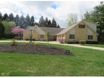 Well-maintained exterior featuring stone accents, manicured lawn, landscaping and basketball hoop at 2427 Cedar Bend Dr, Anderson, IN 46011