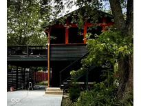 Unique home featuring multi-tiered decks and covered parking, surrounded by mature trees at 256 Riverwood Dr, Noblesville, IN 46062