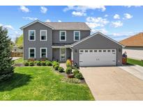 Charming two-story home with a well-manicured lawn, beautiful landscaping, and a two-car garage at 272 Van Buren St, Greenfield, IN 46140