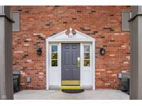 Charming brick exterior with a gray front door and decorative white trim, offering a warm welcome to this lovely home at 3127 E 52Nd St # C, Indianapolis, IN 46205