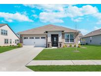Charming single-story home with a well-manicured lawn and attached two car garage at 5218 Pinehurst Ct, Whitestown, IN 46075