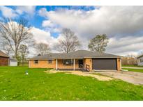 Cozy single-story brick home features a two-car garage and well-maintained lawn at 5576 N Heritage Ln, Alexandria, IN 46001