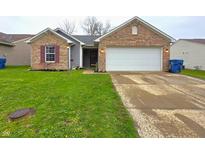 Charming single-story home with brick and siding, a well-manicured lawn, and an attached two-car garage at 5848 Jackie Ln, Indianapolis, IN 46221