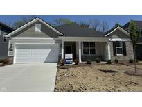 Charming single-story home showcasing a two-car garage and manicured front yard at 6474 Ambassador Dr, Plainfield, IN 46168