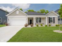 Charming single-story home featuring a manicured lawn, attached garage, and a welcoming front porch at 6474 Ambassador Dr, Plainfield, IN 46168