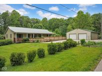Inviting home featuring a charming porch, well-manicured lawn, and a convenient two-car detached garage at 685 N Buffalo Hill Rd, Martinsville, IN 46151
