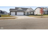 Charming one-story home with a three car garage, neutral siding, and a well manicured lawn at 7067 Hart St, Cumberland, IN 46229