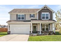 Charming two-story home with a covered front porch and an attached two-car garage at 7901 Apalachee Dr, Indianapolis, IN 46217