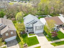 Aerial view of a charming two-story home with a well-maintained lawn and mature trees at 853 Westpointe Dr, Shelbyville, IN 46176