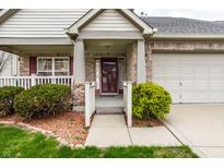 Inviting brick home featuring a charming front porch and well-maintained landscaping, a warm welcome to visitors at 8618 Turnstone Ct, Indianapolis, IN 46234