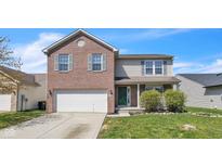 Charming two-story home featuring a brick and siding facade, attached two car garage, and a well manicured front lawn at 8888 N White Tail N Trl, McCordsville, IN 46055
