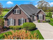 Beautiful brick home featuring manicured landscaping, large windows, and a well-maintained lawn at 10911 Innisbrooke Ln, Fishers, IN 46037