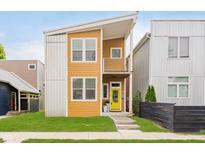 Modern two-story home featuring a yellow front door, second-story balcony, and manicured front lawn at 1453 English Ave, Indianapolis, IN 46201