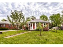 Charming brick home with a well-maintained lawn and a welcoming red front door at 1733 N Spencer Ave, Indianapolis, IN 46218
