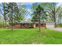 Charming red brick home featuring a spacious front yard with mature trees and an attached garage at 2920 N Buck Creek Rd, Greenfield, IN 46140